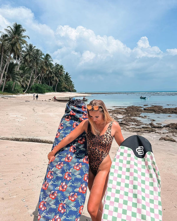 Mum on mothers day going for a surf with two surfboards on the beach with Boardsox covers on each