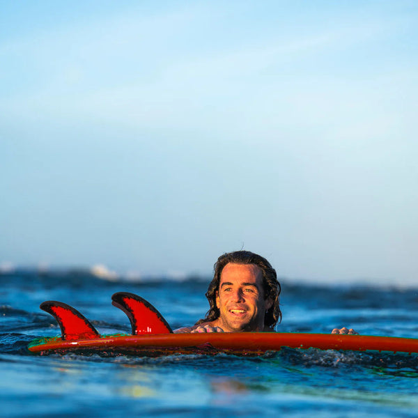 Mason Ho with the FCS II Code Red Tri Fin Set on a Surfboard for Melbourne Surfboard Shop