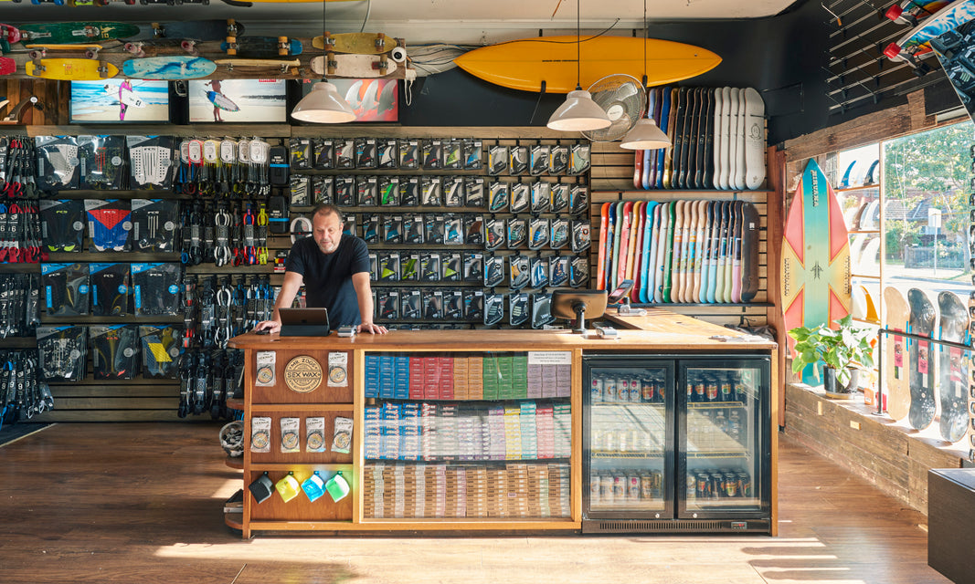 The interior of Melboune Surfboard Shop, showing the range of core surfboard equipment from surf wax, surfboards, surf fins, tailpads and surf leashes.
