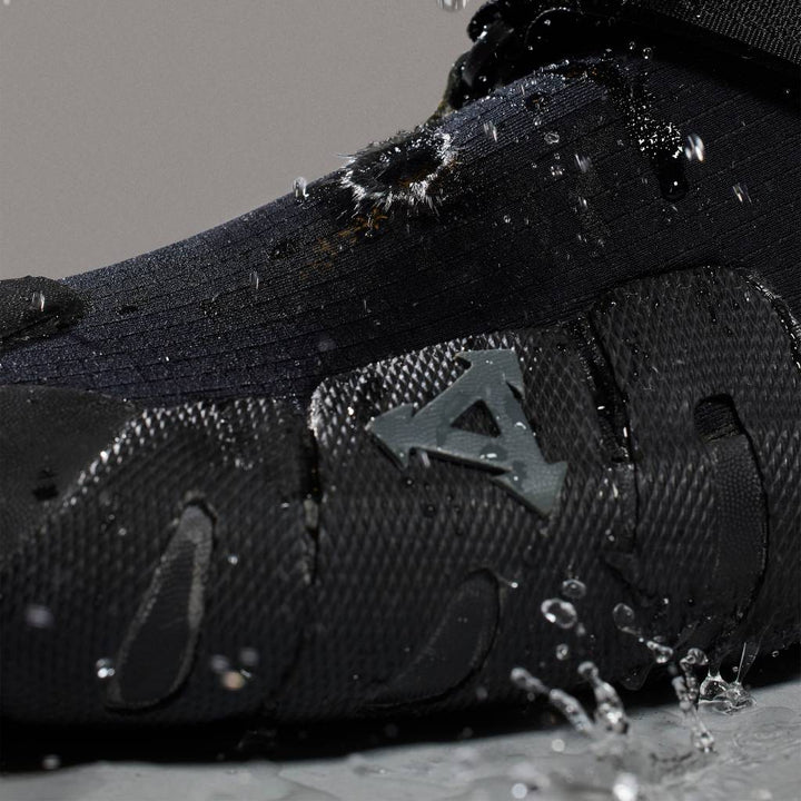 Close-up of black wetsuit surf boot with water splashes, Melbourne surf accessories